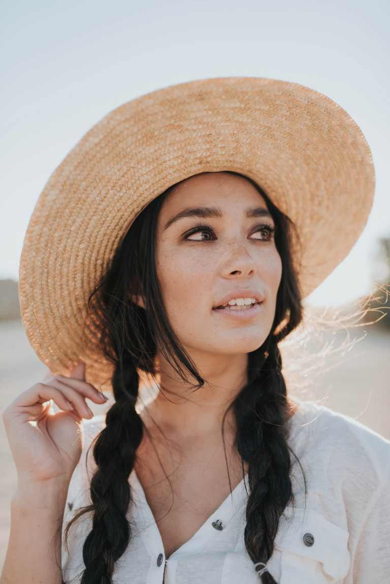 Woman in a wide straw hat with long braids